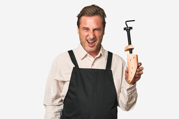 A middle-aged shoe maker screaming very angry and aggressive.