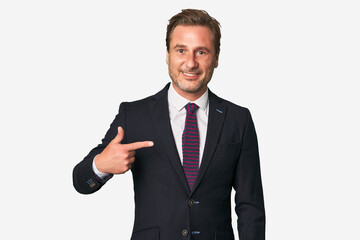 A middle-aged businessman isolated person pointing by hand to a shirt copy space, proud and confident