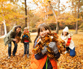 Family playing in autumn leaves