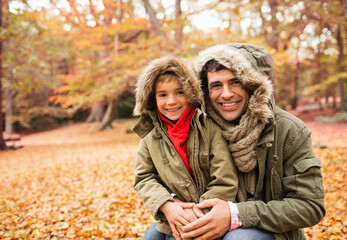 Father and son smiling in park
