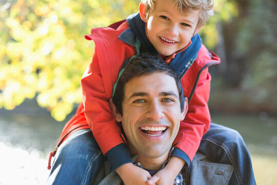 Father carrying son on shoulders in park