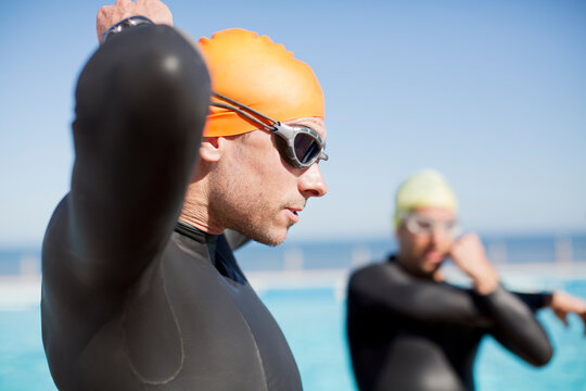 Triathlete tying on goggles outdoors