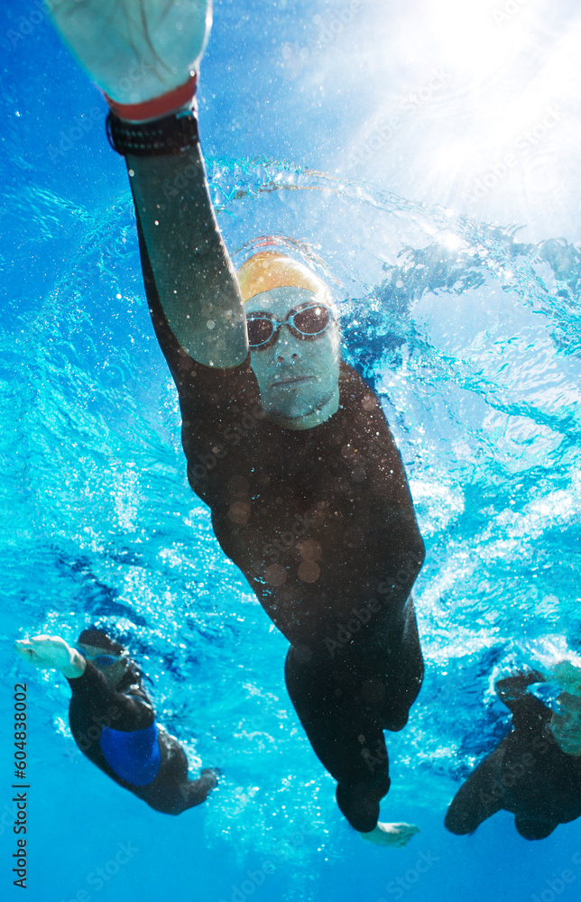 Wall mural Triathletes in wetsuits underwater