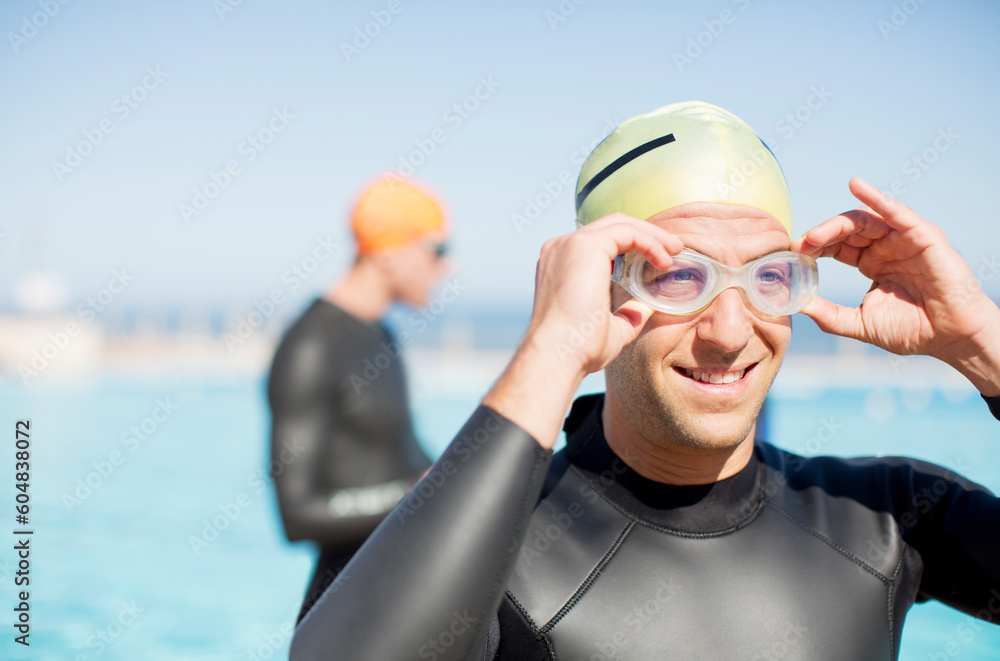 Wall mural triathlete adjusting goggles outdoors