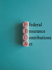 FICA symbol. Concept red words FICA federal insurance contributions act on wooden cubes on beautiful blue background. Business FICA federal insurance contributions act concept. Copy space.