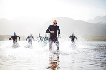 Fototapeta Triathletes emerging from water obraz