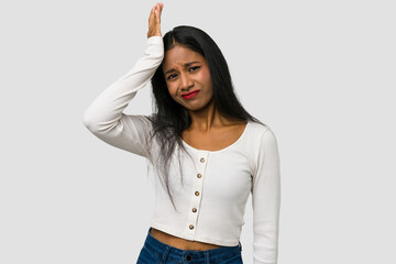 Young Indian woman cut out isolated on white background forgetting something, slapping forehead...