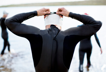 Triathlete adjusting goggles at start of race