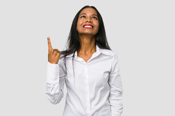 Young Indian woman cut out isolated on white background indicates with both fore fingers up showing...