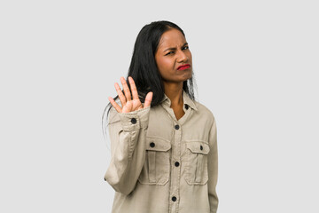 Young Indian woman cut out isolated on white background rejecting someone showing a gesture of...