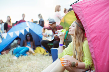 Woman blowing bubbles from tent at music festival