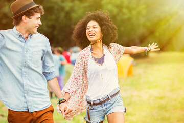Fototapeta premium Happy couple in field outside tents at music festival