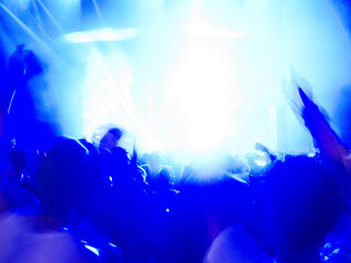 Silhouette of crowd facing illuminated stage
