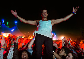 Portrait of confident performer with fans cheering in background