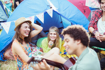 Friends hanging out at tent at music festival © KOTO