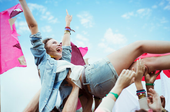 Enthusiastic woman crowd surfing at music festival