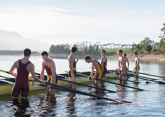 Obraz premium Rowing team placing boat on lake