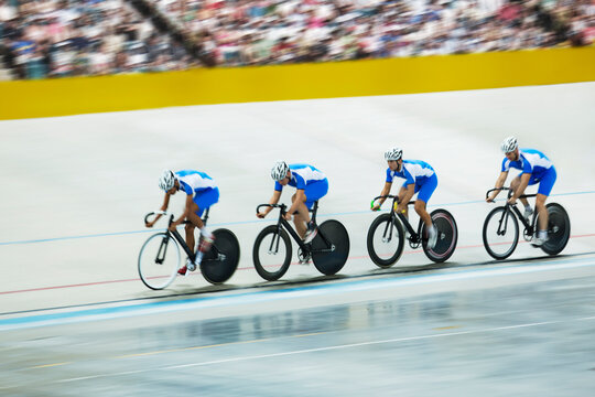 Track cycling team riding around velodrome