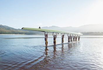 Rowing team holding scull overhead in lake - obrazy, fototapety, plakaty
