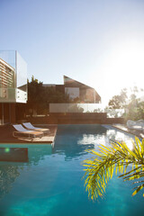 Sun shining over modern house and swimming pool