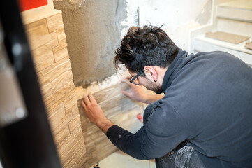 Obraz premium Closeup of a tiler applying tiles to a wall