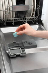 Dishwasher tablet in hand. Soap Dishwashing tablet