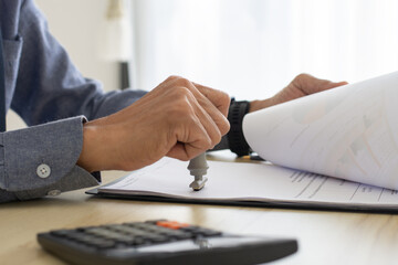 Business man hand stamping rubber stamp on document with digital tablet and calculator on the desk...