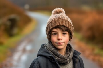 Lifestyle portrait photography of a glad kid male wearing a warm beanie or knit hat against a winding country road background. With generative AI technology