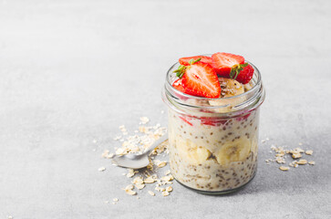 Overnight Oats with Fresh Strawberry, Banana and Chia Seeds in Jars on Light Grey Background, Healthy Snack or Breakfast