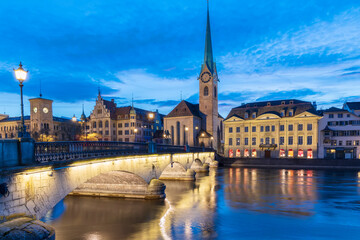 Panorama landscape along Limmat river in twilight sunset with background.Blue sky in the evening.Winter season in Switzerland with reflection on Limmat river.Colorful light cityscape.Clock and bridge.