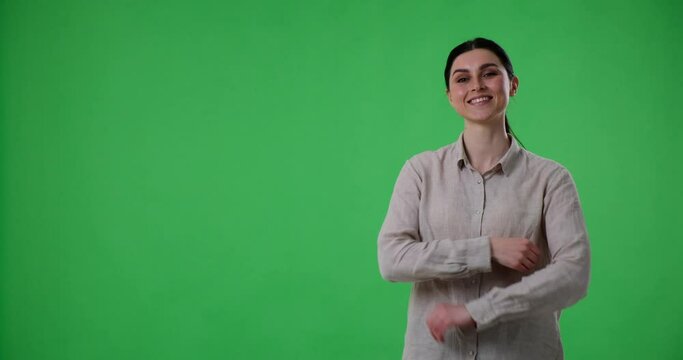 Confident woman is standing on a green background and pointing to the left side of the frame while presenting three options. With her index finger, she directs the viewer's attention to the choices.