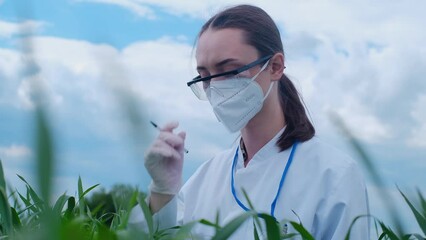 Portrait of a caucasian woman in goggles and a white uniform smiling at the camera, standing on a farm. The laboratory assistant is confident in the benefits of organic greens. - Powered by Adobe