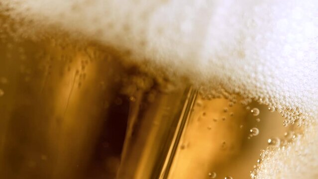 Craft beer closeup. Craft IPA microbrewery. Refreshing craft IPA beer is running in stunning high-speed 4K footage, forming appetising froth. Stunning liquid