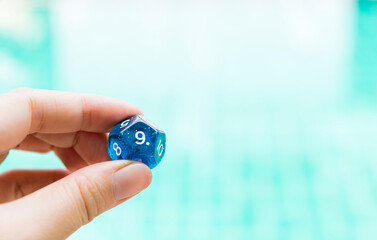 Dice divination in girl hand over blurred swimming pool background, Numerology dices fortune telling divination tools