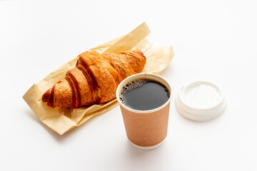 One paper cup of coffee with croissant. Takeaway coffee with snack