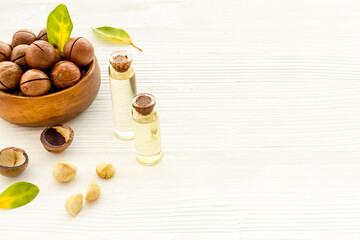 Bottles of macadamia nuts oil with raw nuts. Natural oil for cosmetic or cooking