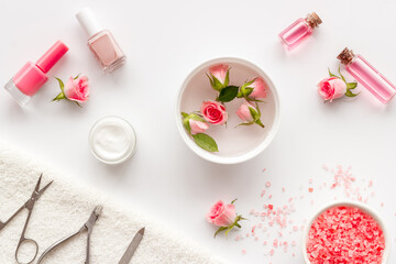 Fototapeta na wymiar Professional manicure tools with pink roses flowers. Beauty care salon spa.