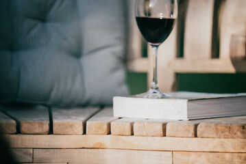 Glass of red wine and a book on a couch