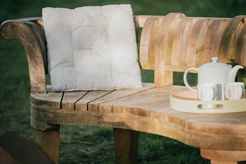 Tea placed on a wooden bench in the garden  
