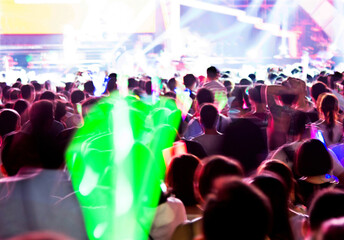 Silhouette raising glow stick in the music festival