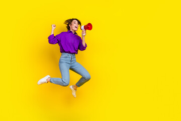 Fototapeta na wymiar Full length photo of cool lucky lady wear violet shirt jumping shouting bullhorn empty space isolated yellow color background