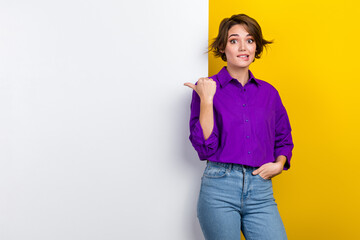 Photo of young marketer lady wear purple shirt bite lips doubtful directing finger paper billboard...