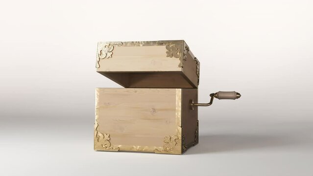 An ornate antique jack-in-the-box made of wood and gold trimmings getting wound up and then popping open on an isolated white studio background 