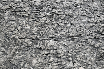 Close-up texture of a rock cut with expressive textures of stone and geological layers.