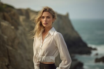 Lifestyle portrait photography of a tender mature girl wearing a sophisticated blouse against a dramatic coastal cliff background. With generative AI technology