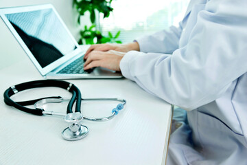 Doctor working with laptop in hospital office