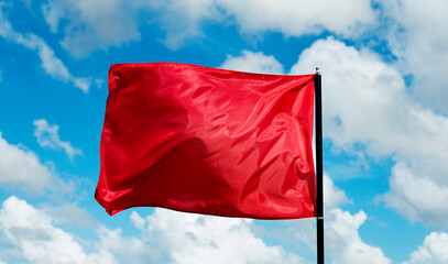 Red flag waving against blue sky