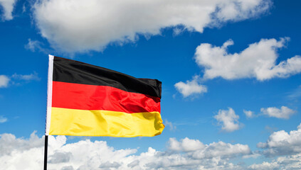 German flag waving against blue sky