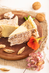 Walnut and almond cake on white wooden, side view, selective focus