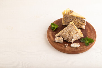 Walnut and almond cake on white wooden, side view, copy space.